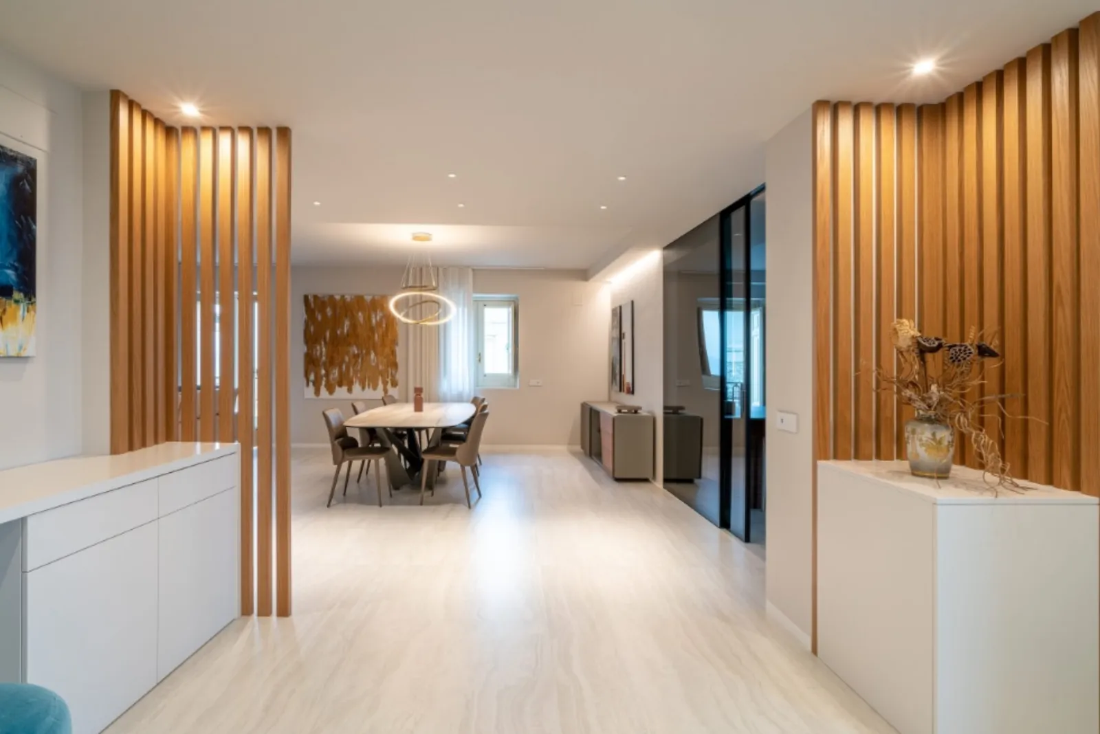 Corridoio con listelli verticali in rovere e zona pranzo sullo sfondo