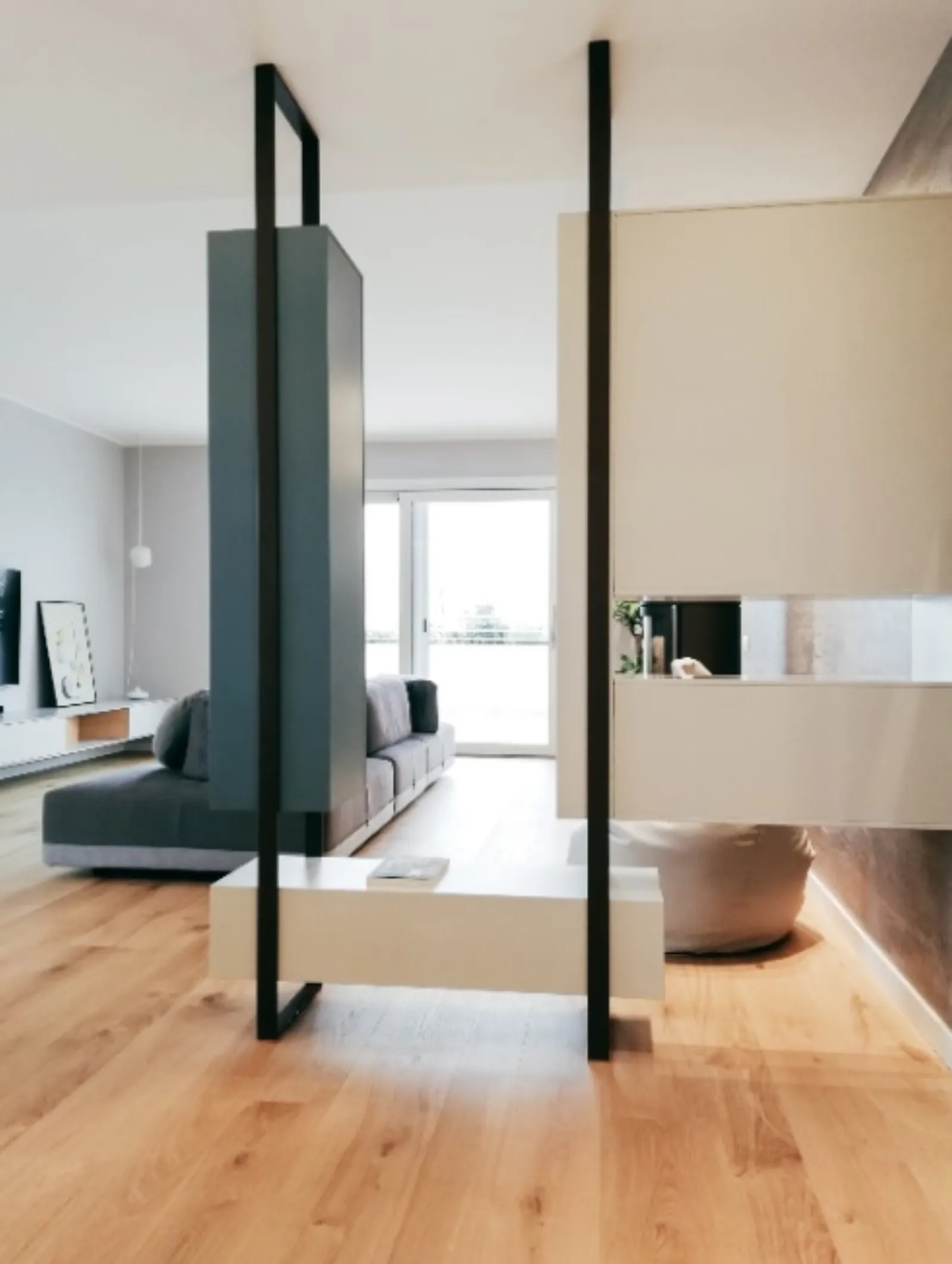 Divisorio scultoreo tra living e ingresso con pannelli neri e beige
