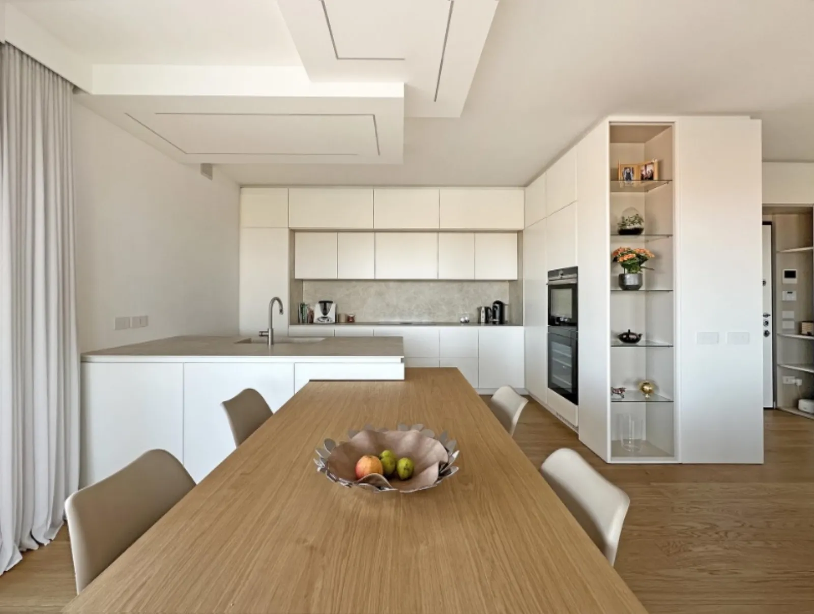 Zona pranzo in rovere con cucina e libreria a giorno