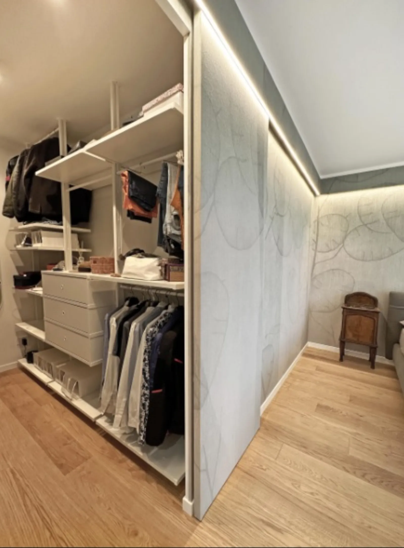 Cabina armadio aperta con strutture in metallo bianco e luci a led