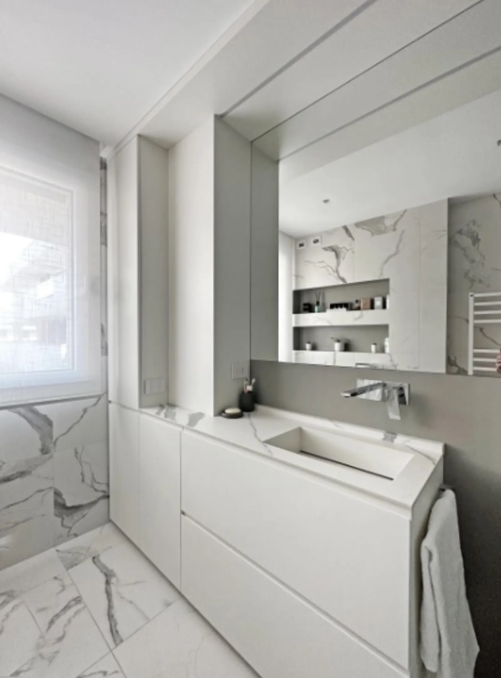 Secondo bagno con lavabo scolpito in pietra e top effetto marmo