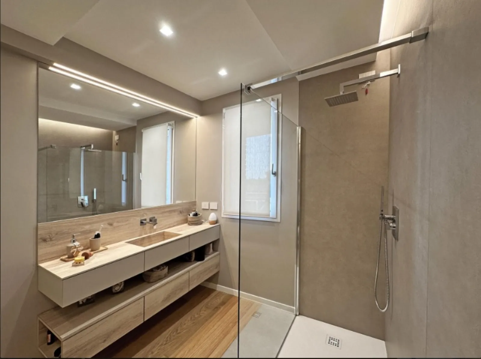 Bagno padronale effetto pietra con doccia walk-in e mobile in rovere