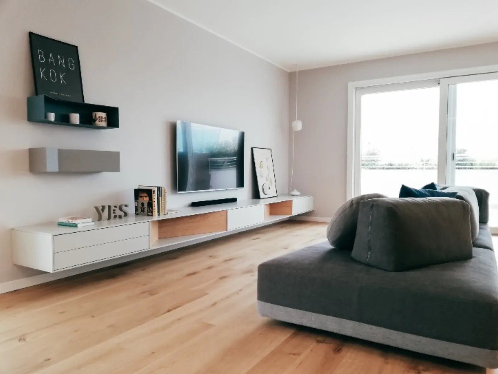 Living con chaise longue grigia e parete attrezzata TV su misura