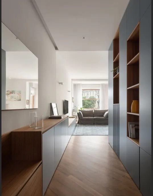 Corridoio d'ingresso con boiserie e libreria su misura