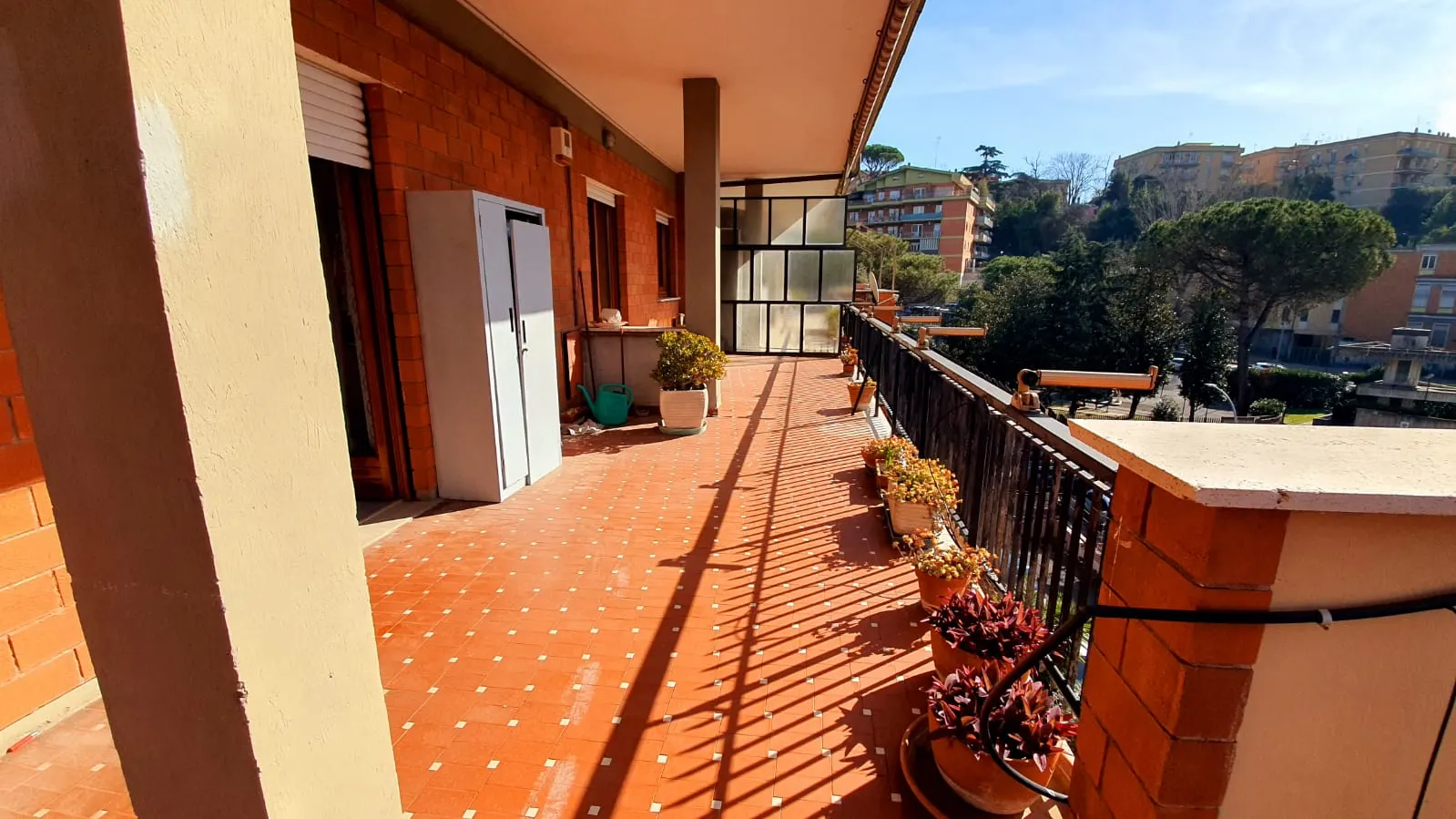 Lato del terrazzo con vetrata laterale, fioriere e affaccio su Monte Mario