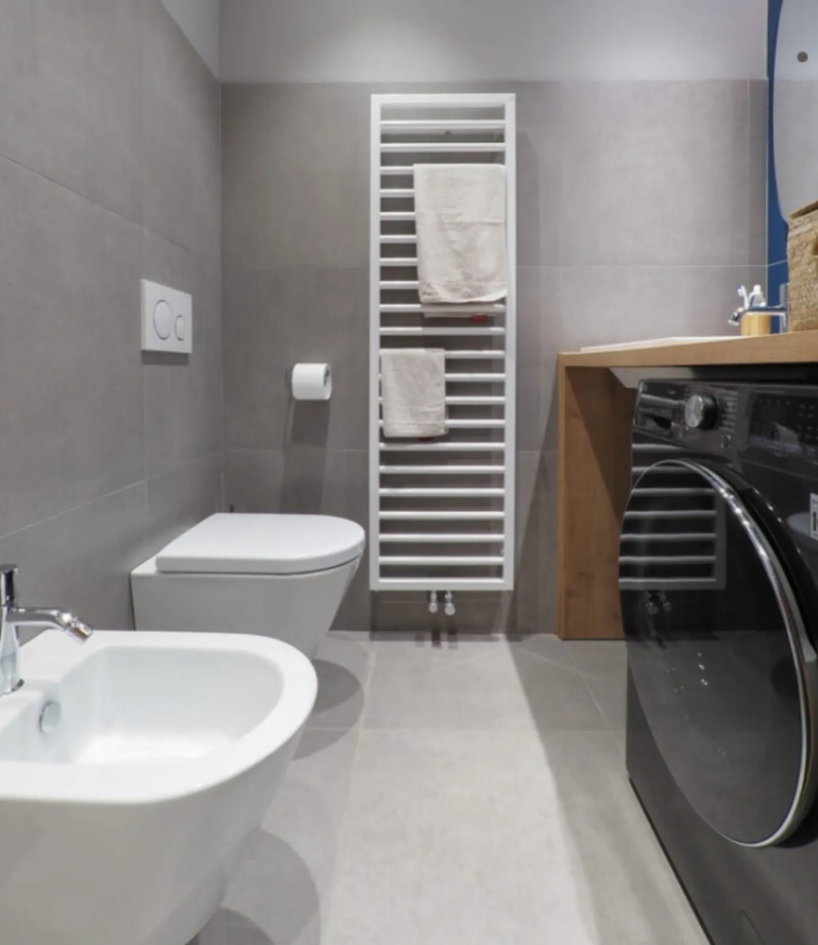 Bagno effetto pietra con sanitari sospesi e lavatrice integrata