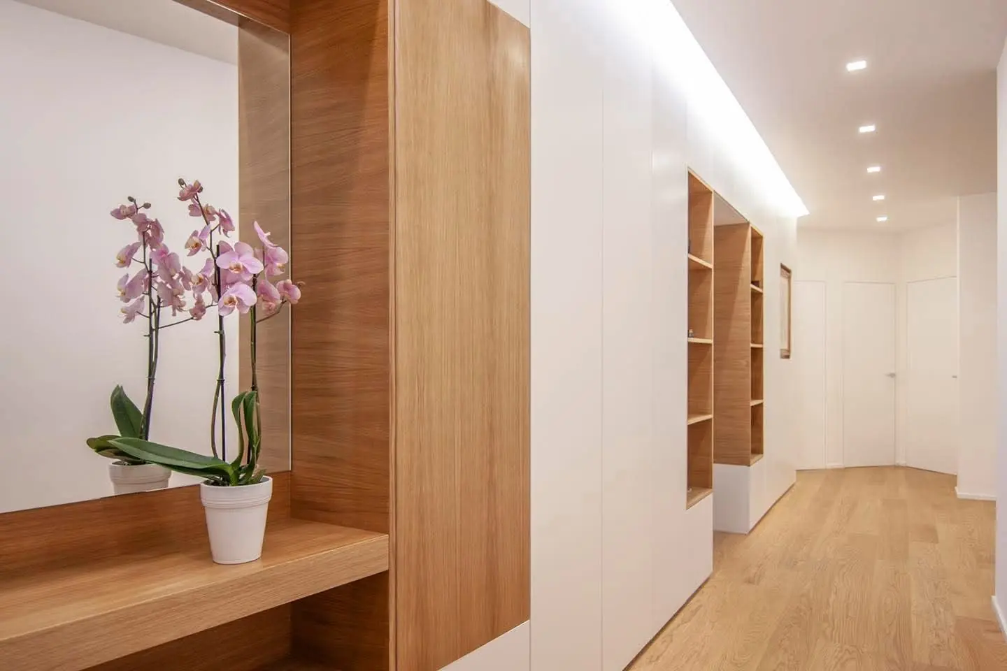 Ingresso con boiserie in rovere e mensole su misura