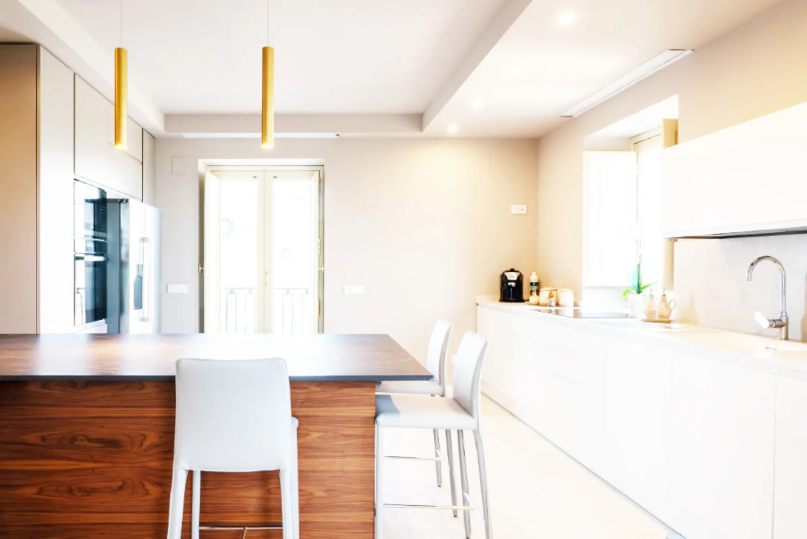 Cucina con isola in legno e sospensioni cilindriche dorate