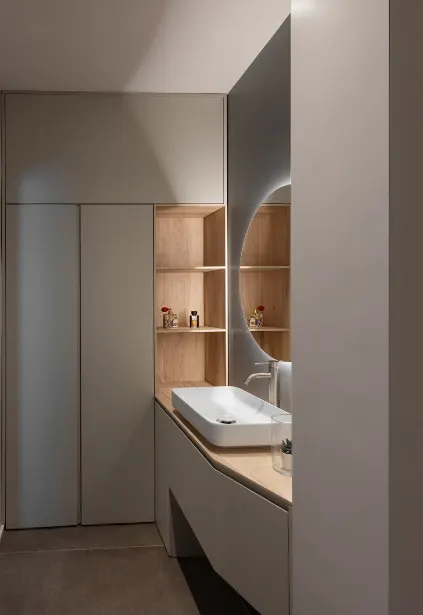 Secondo bagno con boiserie in rovere, nicchie illuminate e lavabo bianco