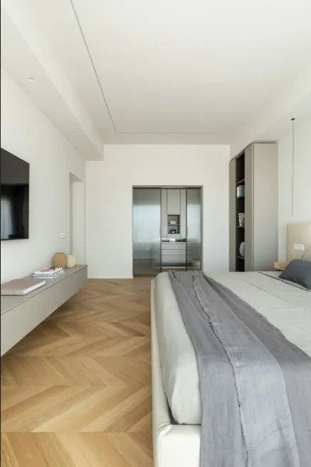 Camera da letto, dettaglio parete TV e parquet a spina di pesce
