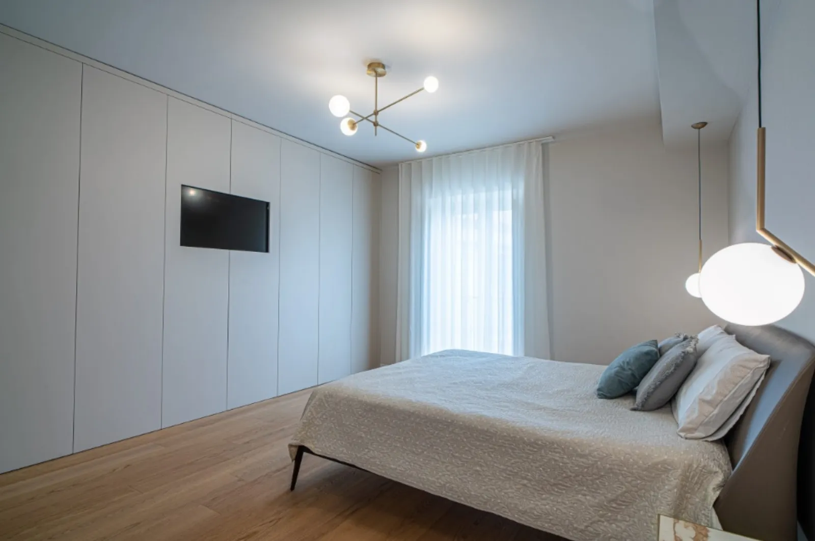 Camera da letto con parete armadio integrata e sospensione globo