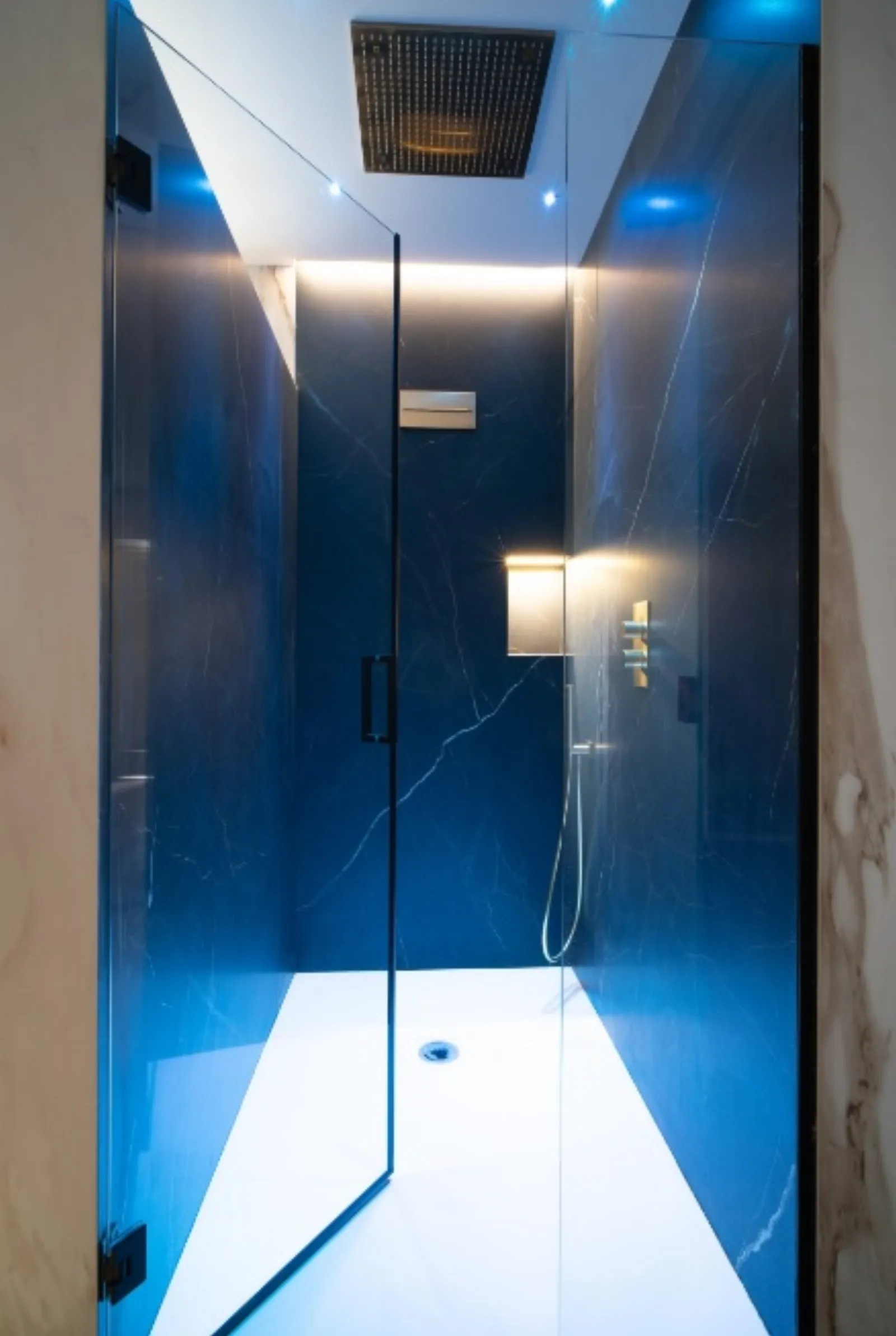 Doccia rivestita in marmo blu intenso con soffione a pioggia
