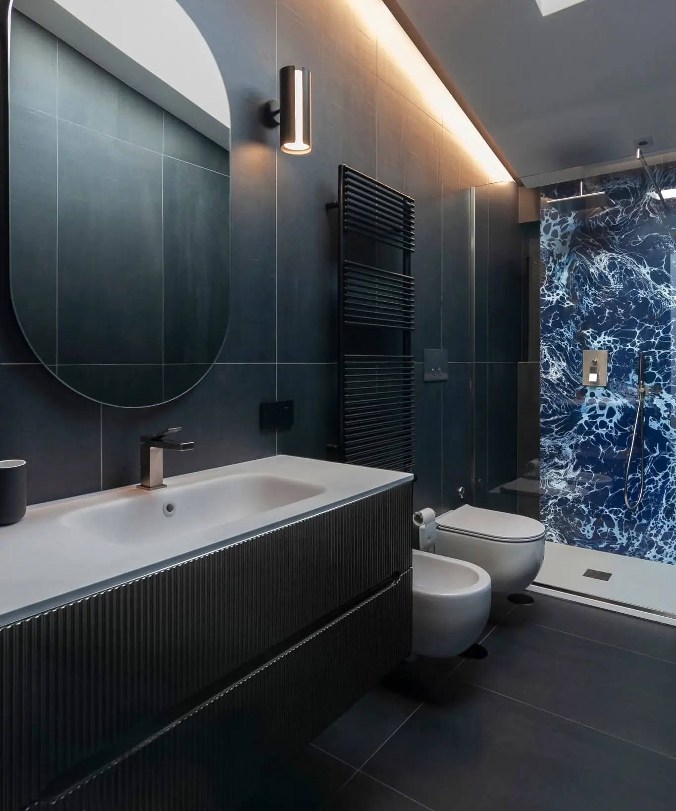 Bagno padronale, mobile a doghe e finiture scure
