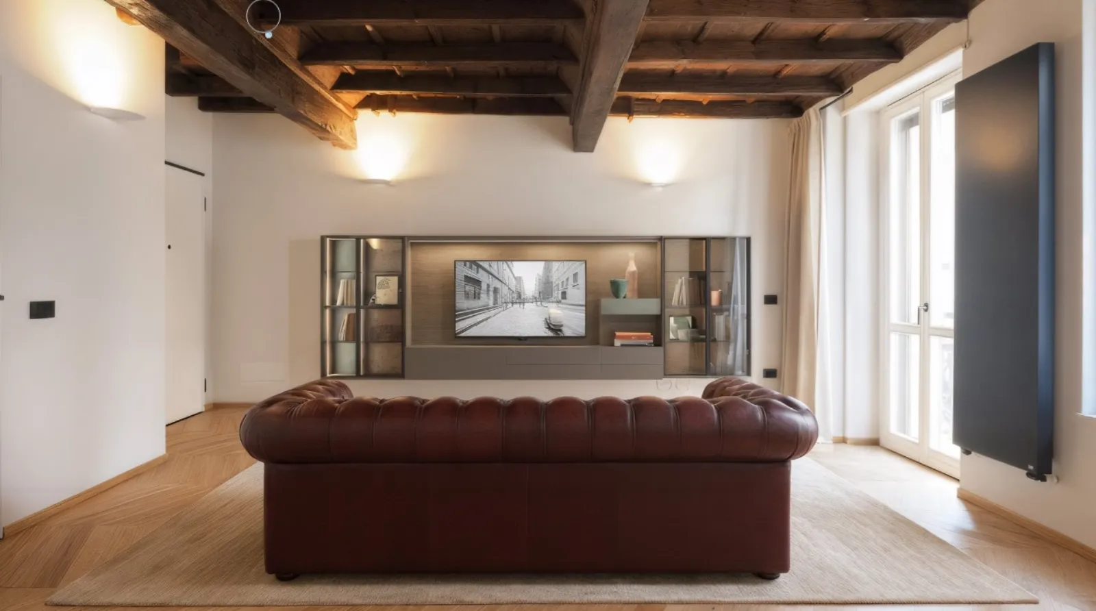 Living con divano Chesterfield in pelle e parete TV su misura