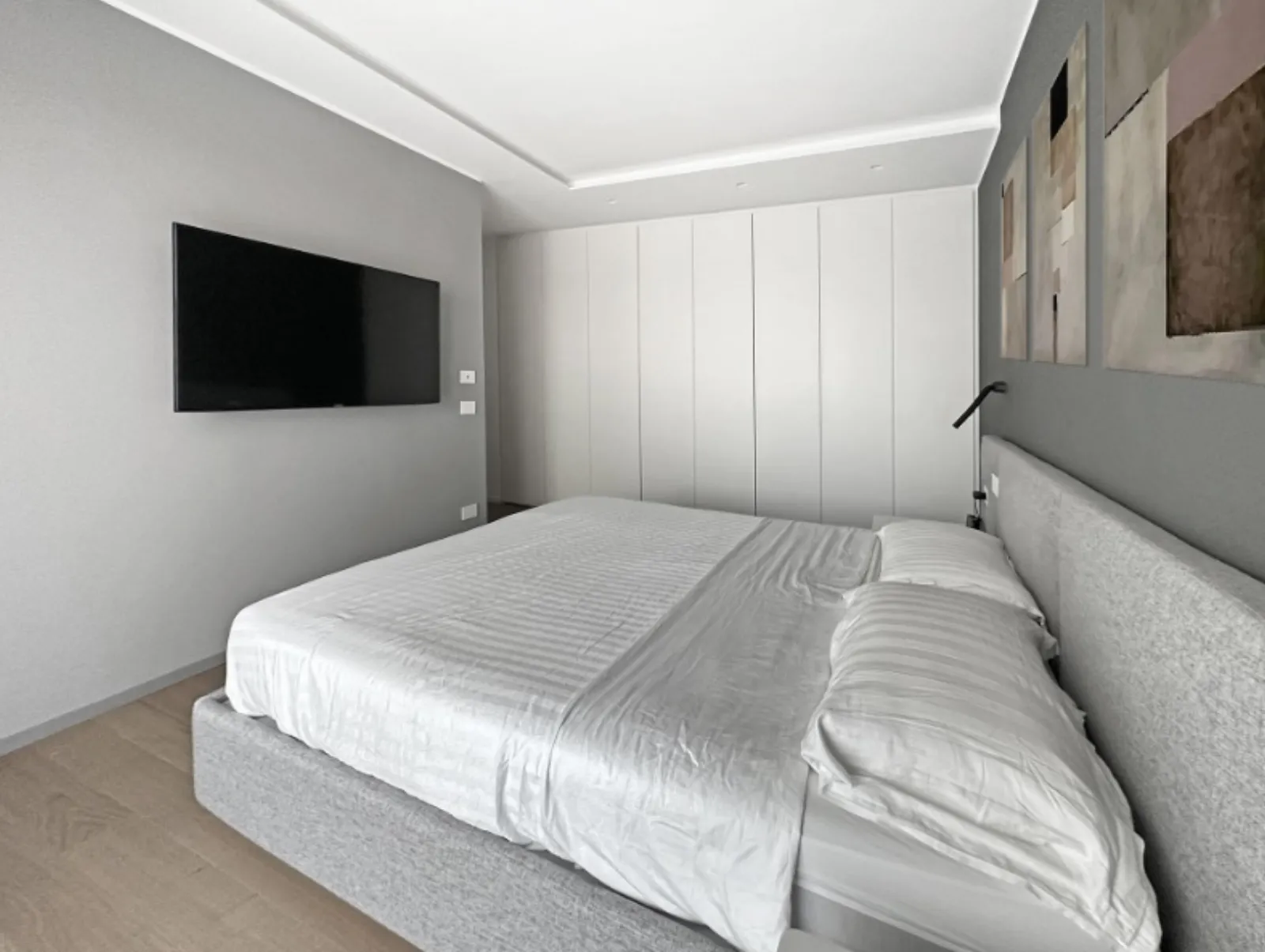 Camera da letto con TV a parete e armadio a tutta altezza