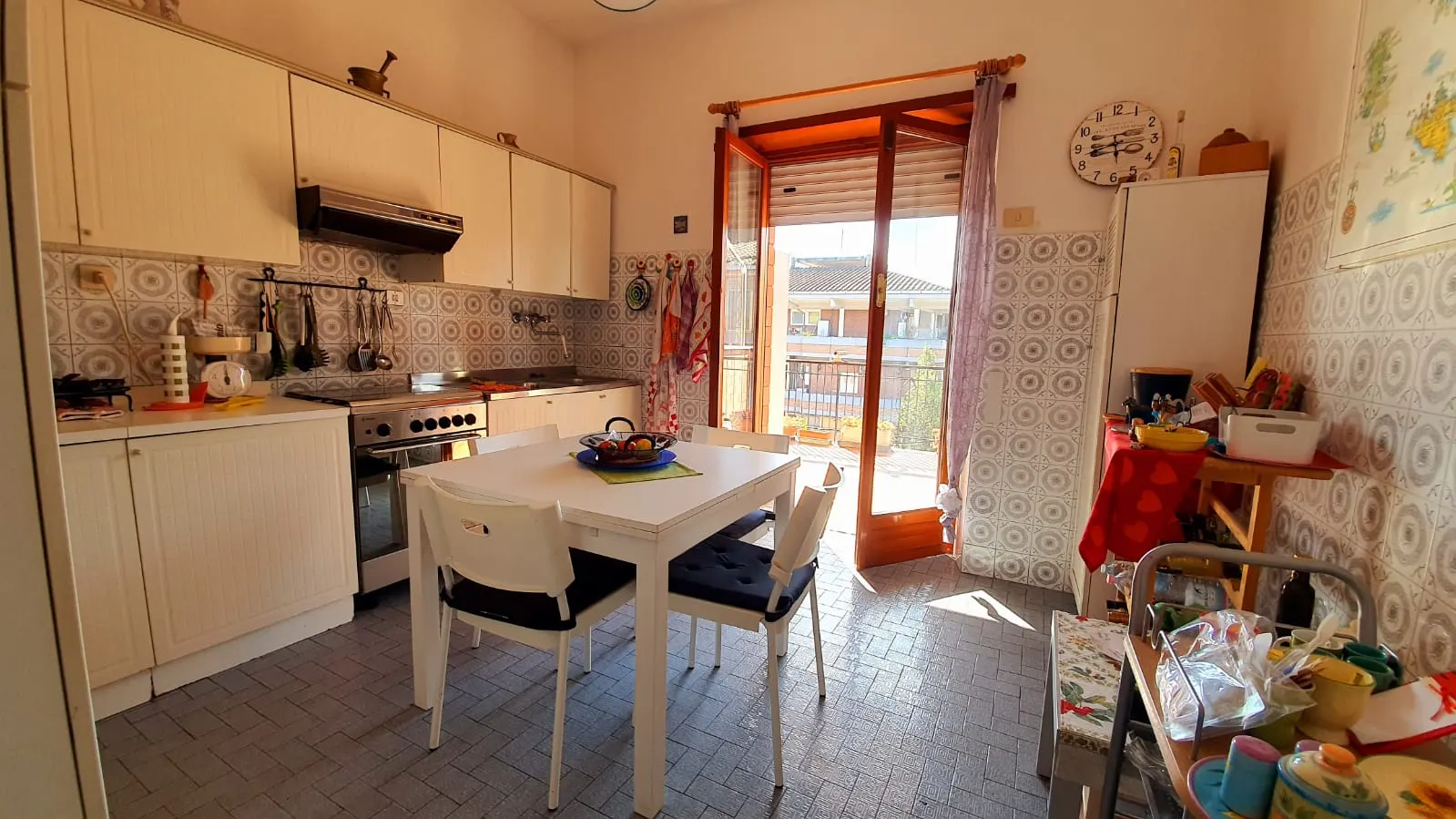 Vista d'insieme della cucina abitabile con tavolo e affaccio sul balcone