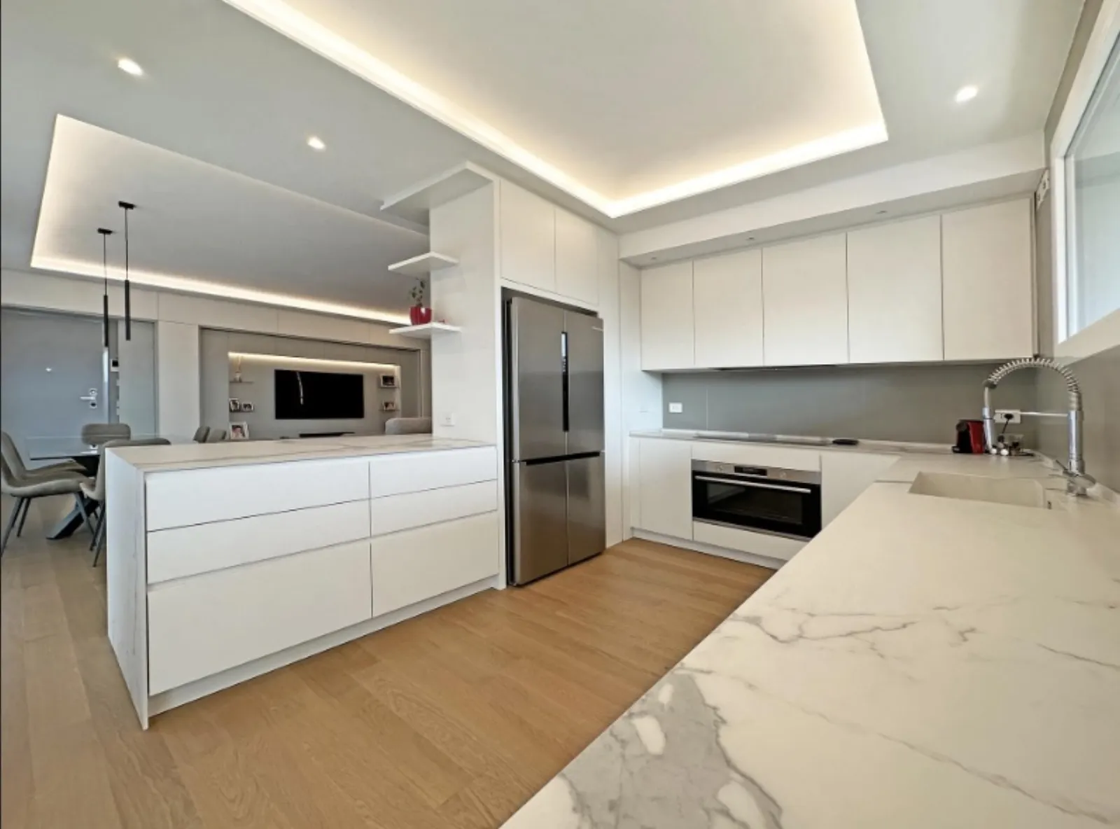 Cucina con isola e top in marmo verso il living