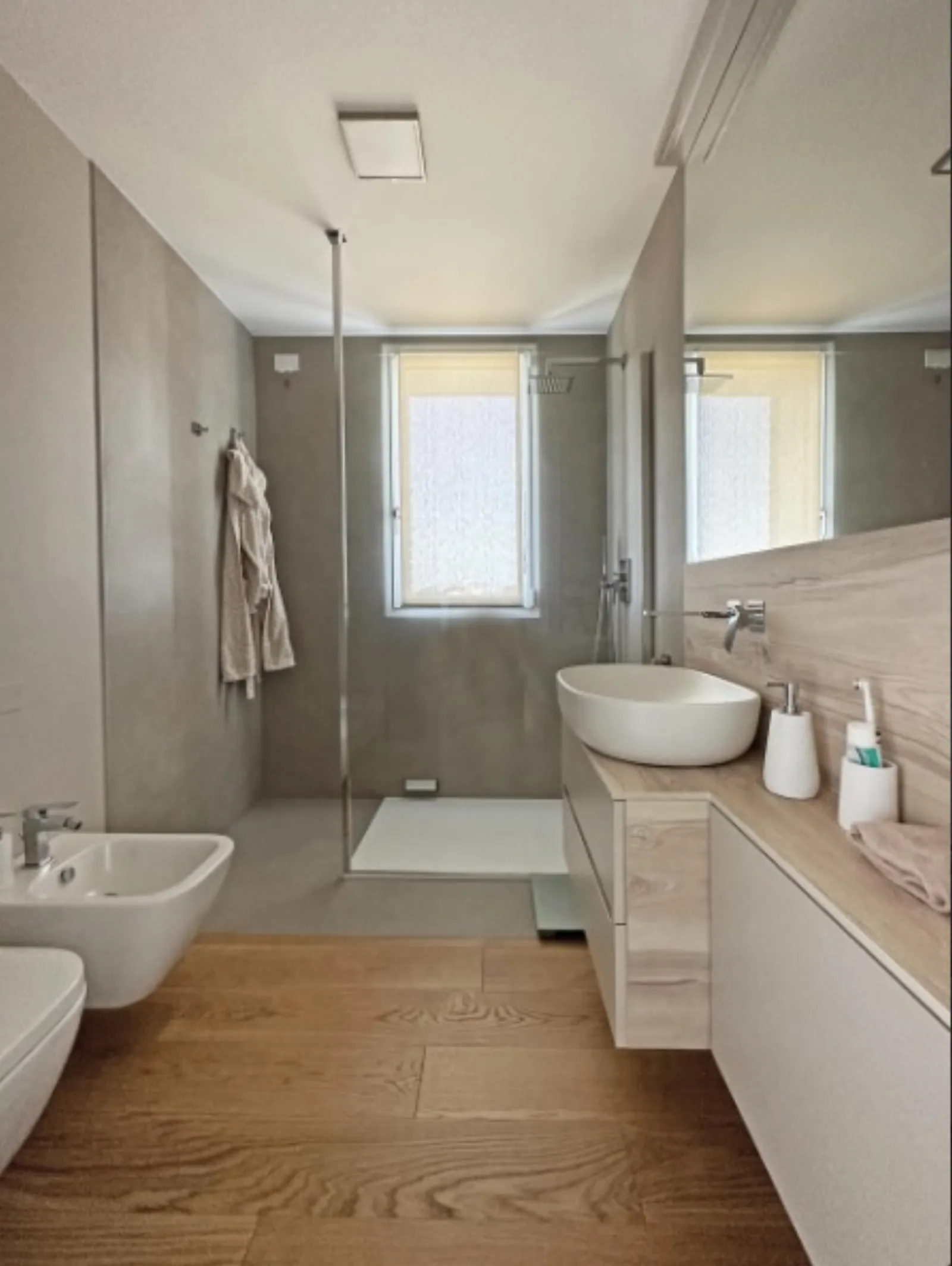 Bagno con doppio lavabo in ceramica, doccia ampia e mobile in rovere