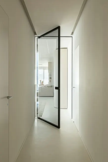 Corridoio con porta a bilico in vetro e profilo nero
