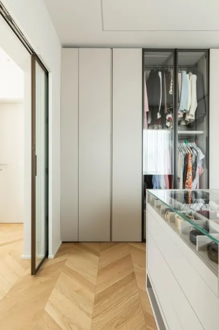 Cabina armadio con ante a tutta altezza e parquet a spina di pesce